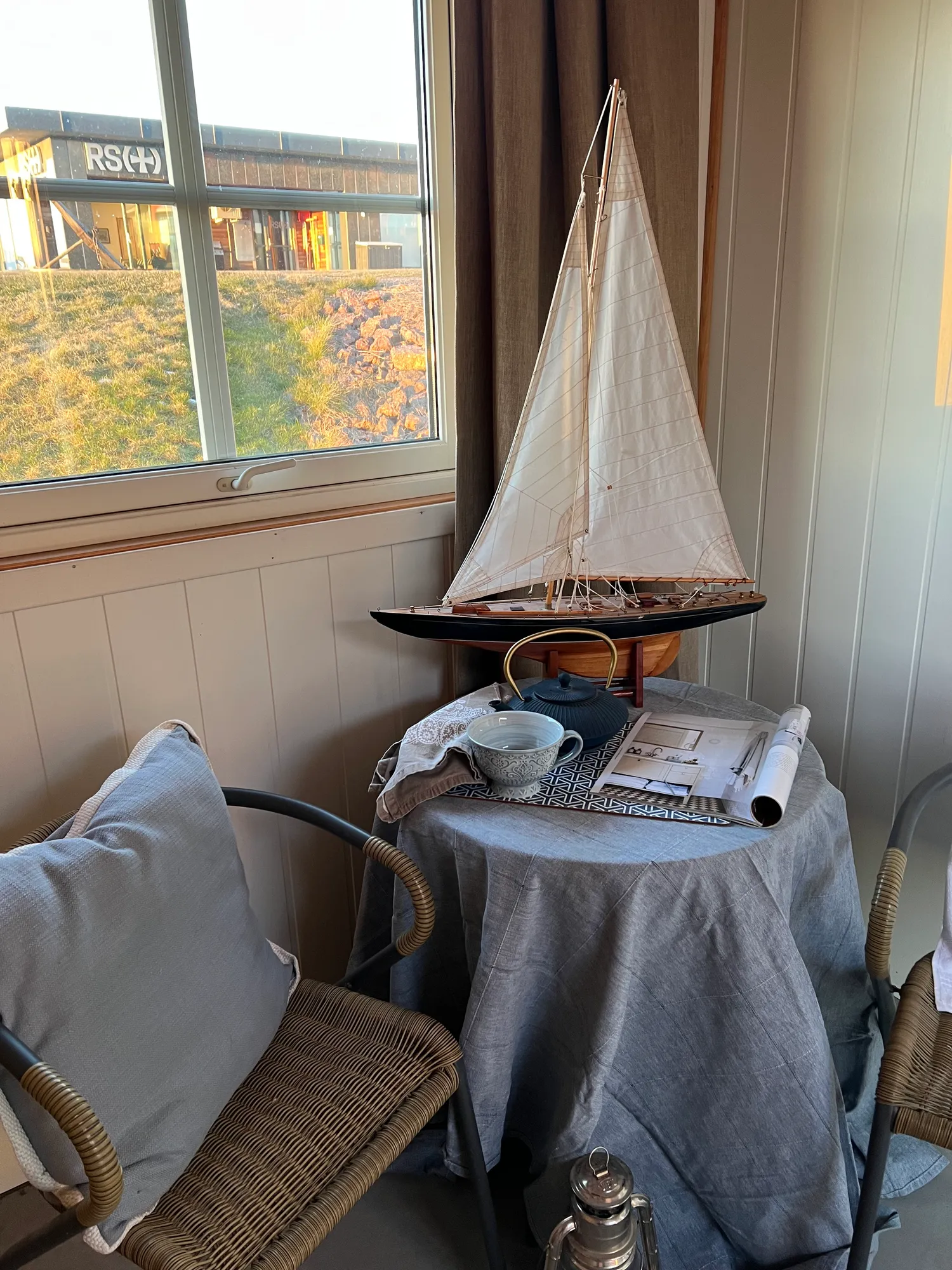 Seilbåtmodell på bord med duk ved vinduet